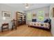 Comfortable bedroom with hardwood flooring, filled with natural light, and featuring a bookcase at 30119 Settle, Chapel Hill, NC 27517