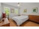 Bright bedroom featuring hardwood floors, two windows, and simple furnishings at 30119 Settle, Chapel Hill, NC 27517