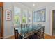 Dining area featuring a clear glass table, wood chairs, and shuttered windows providing bright natural light at 30119 Settle, Chapel Hill, NC 27517
