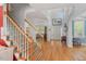 Grand foyer featuring hardwood floors, a staircase with detailed tile risers, and ample natural light at 30119 Settle, Chapel Hill, NC 27517