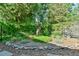 Landscaped backyard with a metal bird sculpture and lush greenery at 308 Rainbow Dr, Carrboro, NC 27510