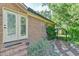 Brick house exterior with glass doors, manicured shrubbery, and stone pathway at 308 Rainbow Dr, Carrboro, NC 27510
