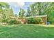 Lush green backyard featuring a wooden pergola and privacy landscaping at 308 Rainbow Dr, Carrboro, NC 27510