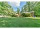 Large backyard featuring a wooden pergola and beautiful green lawn at 308 Rainbow Dr, Carrboro, NC 27510