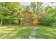 Stone pathway leads to a charming brick home with access to a wooden deck in the backyard at 308 Rainbow Dr, Carrboro, NC 27510