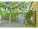Backyard view of brick home with greenery, foliage, and wrought iron gate at 308 Rainbow Dr, Carrboro, NC 27510