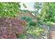 Beautifully landscaped backyard of brick home with a stone path at 308 Rainbow Dr, Carrboro, NC 27510