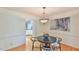 Dining area featuring hardwood floors, stylish lighting, and open doorway to the kitchen at 308 Rainbow Dr, Carrboro, NC 27510