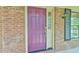 Close up of a plum-colored front door with traditional hardware and sidelight at 308 Rainbow Dr, Carrboro, NC 27510