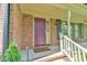 Inviting front door with brick facade and charming architectural details on the covered front porch at 308 Rainbow Dr, Carrboro, NC 27510