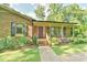 Close up of a brick home's front porch featuring columns and black window shutters at 308 Rainbow Dr, Carrboro, NC 27510