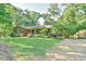 Landscaped front yard featuring a brick home and a fenced yard at 308 Rainbow Dr, Carrboro, NC 27510