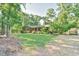 Landscaped front yard featuring a brick home and a fenced yard at 308 Rainbow Dr, Carrboro, NC 27510