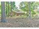 Serene exterior view of a brick home nestled amongst mature trees at 308 Rainbow Dr, Carrboro, NC 27510