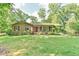 Charming brick home featuring a well-manicured front lawn and inviting front porch at 308 Rainbow Dr, Carrboro, NC 27510