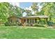 Charming brick home featuring a well-manicured front lawn and inviting front porch at 308 Rainbow Dr, Carrboro, NC 27510