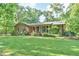 Charming brick home featuring a well-manicured front lawn and inviting front porch at 308 Rainbow Dr, Carrboro, NC 27510