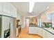 Bright kitchen features stainless appliances, white cabinetry and hardwood floors at 308 Rainbow Dr, Carrboro, NC 27510