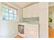 Updated laundry room with washer, dryer and modern cabinets by the window at 308 Rainbow Dr, Carrboro, NC 27510