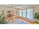 Sunlit living room with hardwood floors, large windows, and access to the dining area at 308 Rainbow Dr, Carrboro, NC 27510