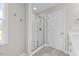 Bathroom with walk-in shower and glass door, white cabinets, and an entry door at 3409 Lemon Springs Rd, Sanford, NC 27332