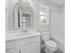 Bathroom with vanity, shower-tub combination, toilet, large window, and modern fixtures at 3409 Lemon Springs Rd, Sanford, NC 27332