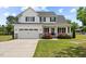Charming two-story home boasts a well-manicured lawn, attached garage, and inviting front porch at 3409 Lemon Springs Rd, Sanford, NC 27332