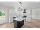 Bright kitchen with white cabinetry, black island, stainless appliances and quartz countertops at 3409 Lemon Springs Rd, Sanford, NC 27332