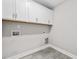 Laundry room with overhead cabinets, tile flooring, utility hookups, and light-colored paint at 3409 Lemon Springs Rd, Sanford, NC 27332