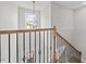 An elegant staircase features an iron railing and leads up to a charming chandelier at 3409 Lemon Springs Rd, Sanford, NC 27332