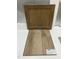 Design studio close-up showing a luxury vinyl wood plank flooring sample and tan kitchen cabinet door at 347 Chesapeake Cmns St # 110, Garner, NC 27529