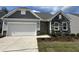 Charming home featuring a two-car garage, stone accents, light gray siding and well-maintained landscaping at 38 Gander Dr, Benson, NC 27504