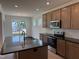 Bright kitchen boasts stainless steel appliances, granite countertops, tile backsplash, and large island at 38 Gander Dr, Benson, NC 27504