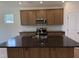Well-lit kitchen with stainless steel appliances, granite counters, tile backsplash, and large island at 38 Gander Dr, Benson, NC 27504