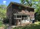 The back of a brick home shows its enclosed back porch and the property's yard at 404 Kinsey St, Raleigh, NC 27603