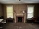 Interior shot of a living room featuring a brick fireplace with mantle and large windows at 404 Kinsey St, Raleigh, NC 27603
