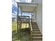 A raised wooden back porch with stairs leading to a grassy yard offers outdoor relaxation and entertainment space at 42 Hemming Ct, Cameron, NC 28326