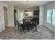 Open dining area featuring hardwood floors, modern lighting, and an adjacent open kitchen space at 42 Hemming Ct, Cameron, NC 28326
