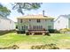 Rear exterior view featuring a wooden deck, manicured yard, and privacy fence at 4404 Triland Way, Cary, NC 27518