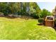 Well-kept backyard with lush green grass, mature trees, and a partial view of the wooden deck at 4404 Triland Way, Cary, NC 27518
