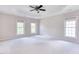 Spacious primary bedroom with tray ceiling, ceiling fan, and large windows at 4404 Triland Way, Cary, NC 27518