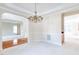 Dining room with classic chandelier, neutral walls, carpet, and archways to additional rooms at 4404 Triland Way, Cary, NC 27518
