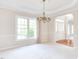 Dining room with a chandelier, neutral carpet, and natural light through large windows at 4404 Triland Way, Cary, NC 27518