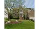 Brick home featuring a well-manicured lawn, mature landscaping, and inviting entry steps to the front door at 4404 Triland Way, Cary, NC 27518