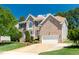Beautiful two-story brick home with a manicured lawn, mature trees, and a welcoming three car garage at 4404 Triland Way, Cary, NC 27518