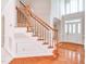 Traditional foyer with wood flooring, grand staircase and a front door with sidelight windows at 4404 Triland Way, Cary, NC 27518