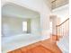 Large living room with hardwood floors, neutral walls, and a staircase with carpeted steps at 4404 Triland Way, Cary, NC 27518