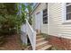 Back door entrance with wooden deck steps and white railing at 4705 Forest Highland Dr, Raleigh, NC 27604