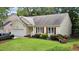 Single-story home with attached garage, verdant lawn, and flowerbed at 4705 Forest Highland Dr, Raleigh, NC 27604