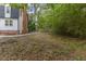 Backyard featuring a brick chimney, lush greenery, and a chain-link fence at 4713 Erwin Rd, Durham, NC 27705